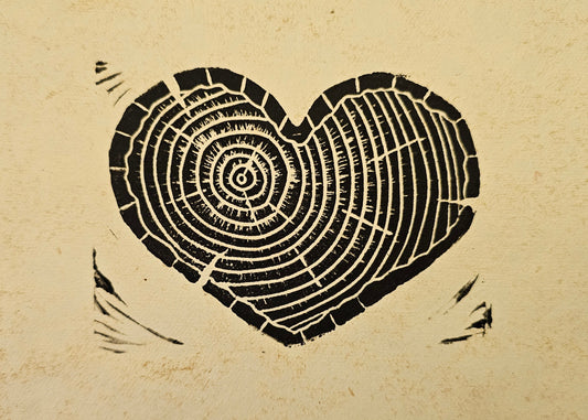 Heart-shaped tree ring cutout on a textured paper background