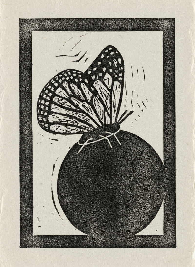 Black and white linocut print of a butterfly on a dark circle with a black border.
