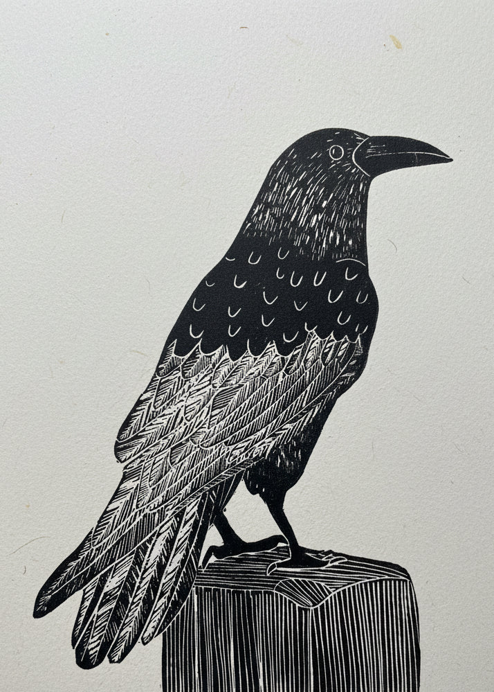 A linoprint Raven sitting on a wooden post