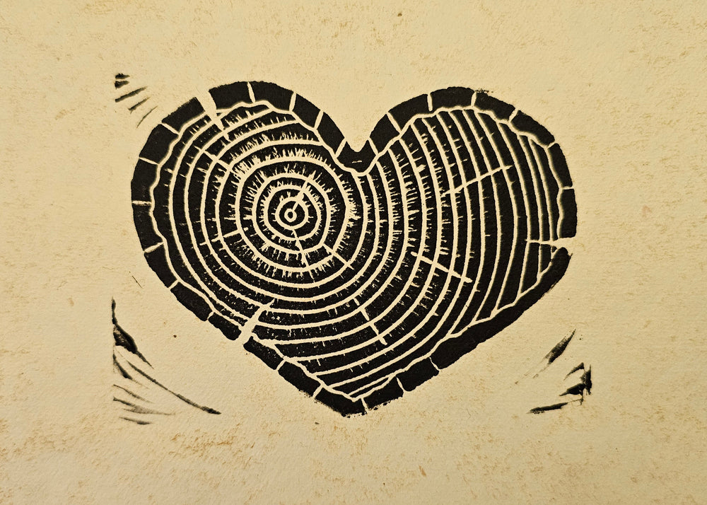Heart-shaped tree ring cutout on a textured paper background