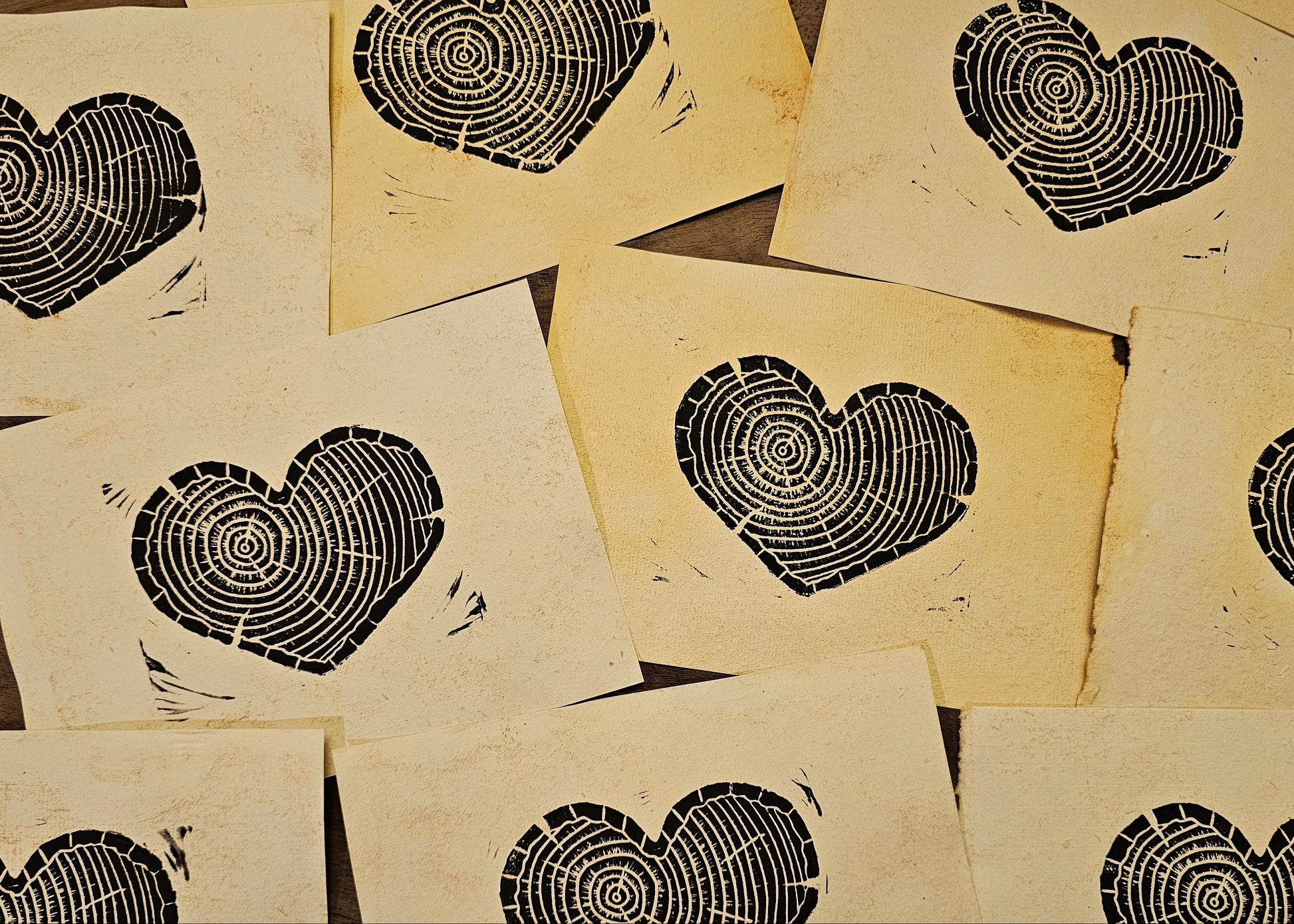 Multiple heart-shaped linoprints on a textured handmade paper